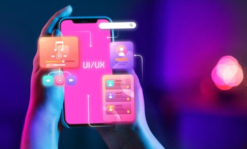 a hand holding a smartphone with colorful UI/UX design interface elements floating above